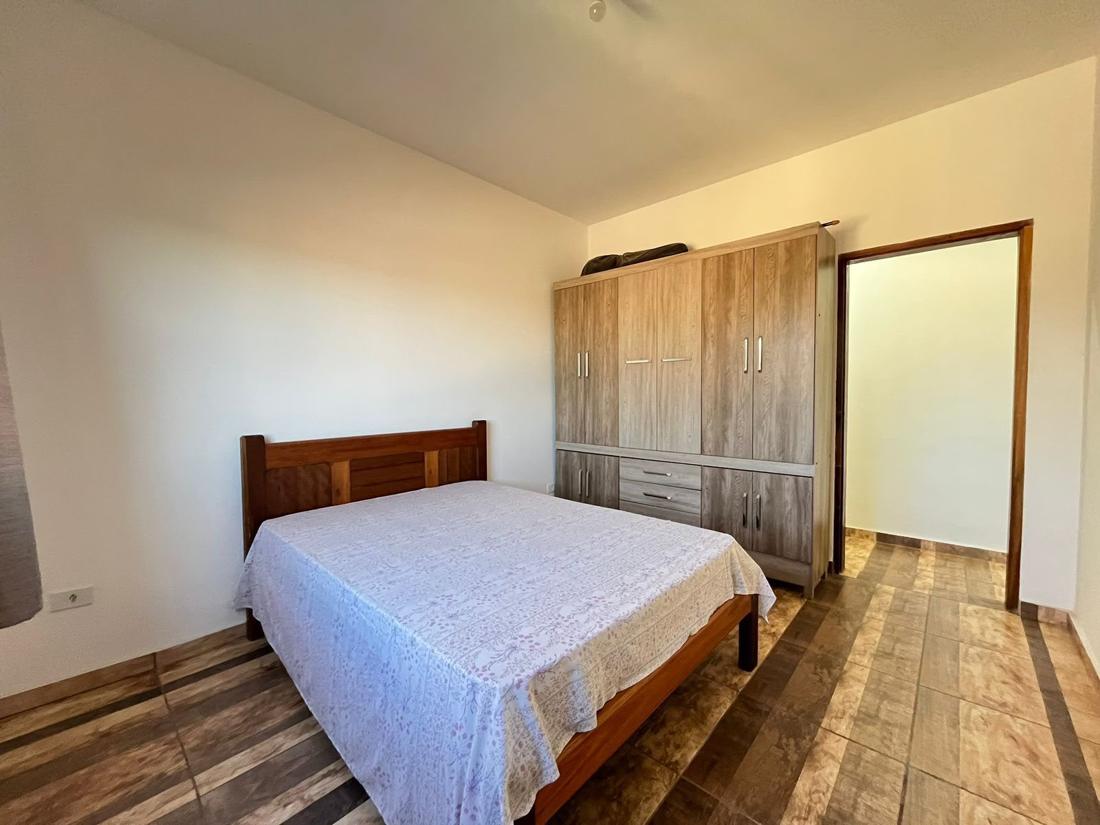 Quarto com cama, guarda-roupa e piso amadeirado